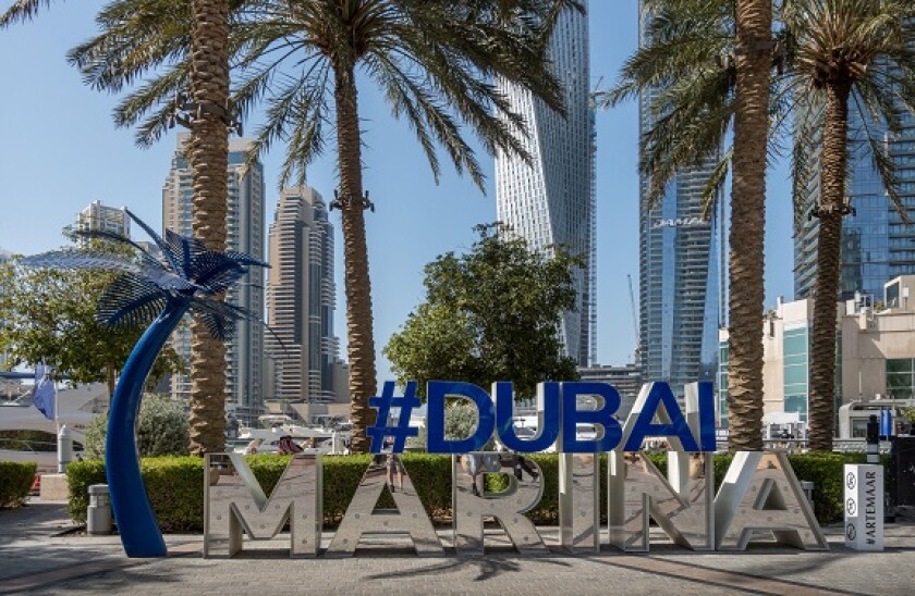 Dubai Marina sign with skyscrapers in the background, United Arab Emirates.