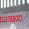 London, UK - June 22, 2018: Closeup of Wells Fargo bank branch entrance with red sign on modern building wall and nobody in England
