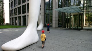kids impressed by big foot Walking Man in front of Muenchener Rueckversicherung Munich Re Bavaria Germany