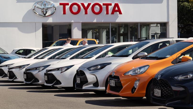 New Toyota vehicles displayed outside dealership showroom in Wellington, New Zealand.