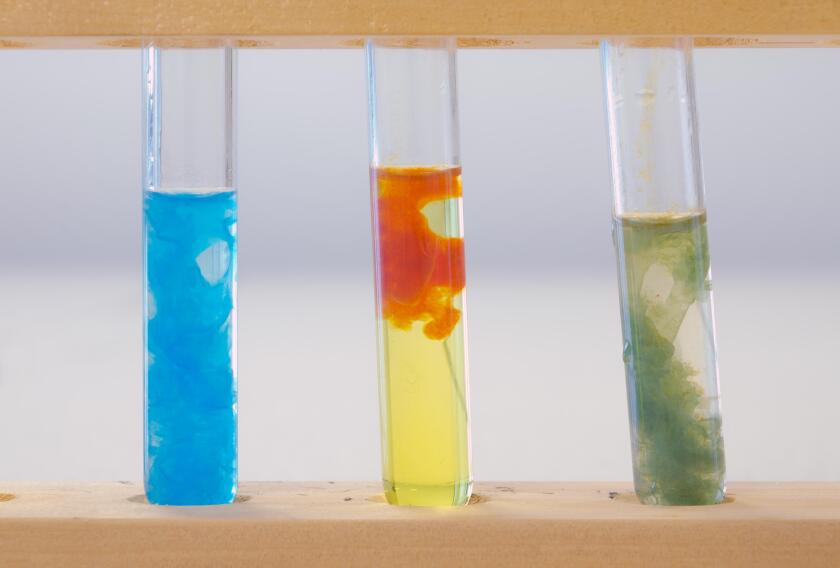 Three test tubes containing (left to right) precipitate of copper hydroxide, precipitate of iron (III) hydroxide and precipitate of iron (II) hydroxid