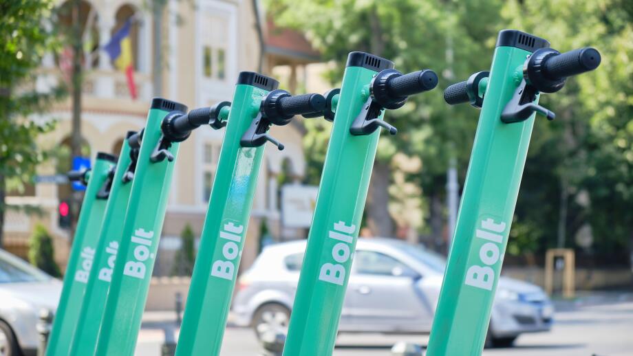Bucharest, Romania - July 16, 2020: Bolt electric scooters parked in a row on a sidewalk. Modern ride sharing, urban transportation alternative in cit