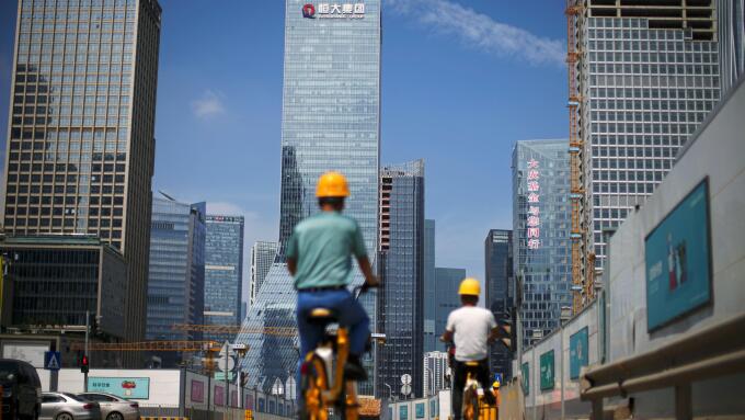 Men ride bicycles past construction sites near the headquarters of China Evergrande Group in Shenzhen, Guangdong province, China September 26, 2021. REUTERS/Aly Song