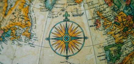 Close-up of a vintage globe showing Europe and the North Atlantic with a detailed compass rose.