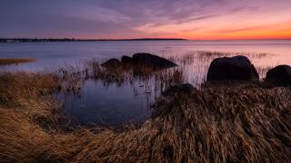A twilight sky glows with color over the calm waters of Long Island Sound (Greenwich Point Park, Greenwich, Connecticut).
