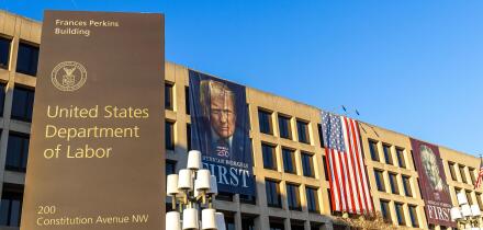 United States Department of Labor headquarters in Washington, DC, with banners of Donald Trump and Theodore Roosevelt reading "American Workers First"