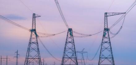 Industrial background group silhouette of transmission towers or power tower, electricity pylon, steel lattice tower at purplr sunset. Texture of high