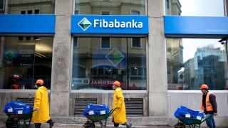 Workmen pushing wheelbarrows pass the private bank Fibabanka in central Istanbul, Turkey. Photo:Jeff Gilbert