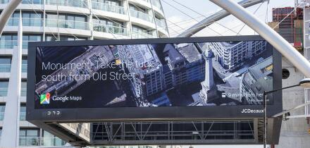 Digital Google Maps billboard at Old Street London displaying Monument Tube directions