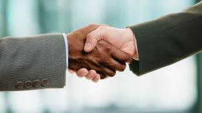 Interracial handshake on business background