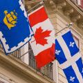 QUEBEC CITY, QUEBEC, CANADA - National and regional flags on display in Quebec City. L-R: City of Quebec; Canada; Quebec