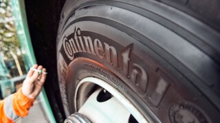A mobile mechanic / tyre fitter checks a coaches continental tire for tread depth during a regular service & safety inspection
