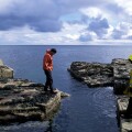 People Standing on Rocky Shore