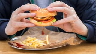 close up view of man's hands with american burger.