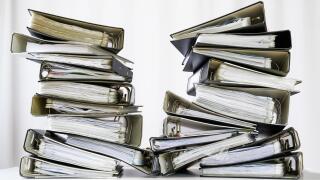 stacks of many ring binder with files, folders and documents on an office desk, concept for too much work and burn out in the business, selected focus