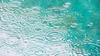 Brazil, Bahia, Trancoso, Raindrops on falling on pond surface