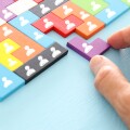 image of tangram puzzle blocks with people icons over wooden table ,human resources and management concept.