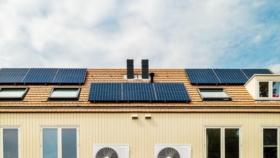 Row of new Dutch houses with solar panels and air-source heat pumps