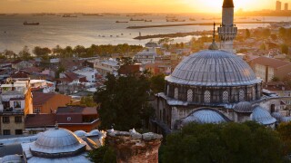 Setting sun behind the Sokollu Mehmet Pasha mosque minaret and historic Dervish ruins on the Marmara Sea Istanbul Turkey