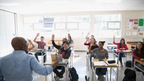High school teacher calling students with hand raised