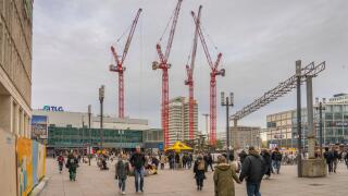 Baukrane auf der Baustelle fur das 130 Meter hohe Covivio-Hochhaus auf dem Alexanderplatz in Berlin-Mitte. Im Hintergrund in der Bildmitte das Haus des Reisens. *** Construction cranes on the building site for the 130-meter Covivio high-rise on Alexanderp
