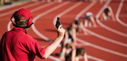Race official holding a starting gun at the beginning of a track event