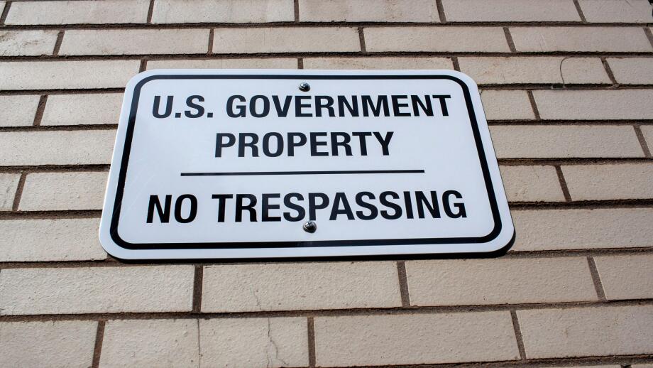 Annapolis, MD 08/21/2020: A white metal plate attached to a brick wall encircling a government building in Annapolis. The sign reads: 'U.S Government