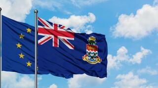 European Union and Cayman Islands flag waving in the wind against white cloudy blue sky together. Diplomacy concept, international relations.