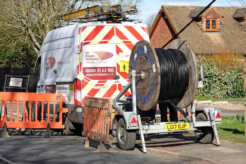 UK Power Networks distribution business van & cable drum trailer replacing electricity network overhead cables supply village location Essex England