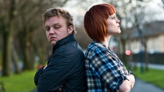 A young couple man and woman having an argument standing back to back not speaking to each other; sulking, not talking