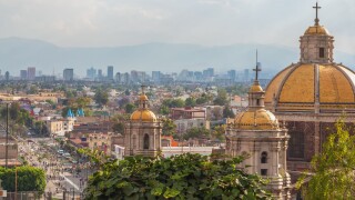Old Basilica of Guadalupe with Mexico City skyline behind it