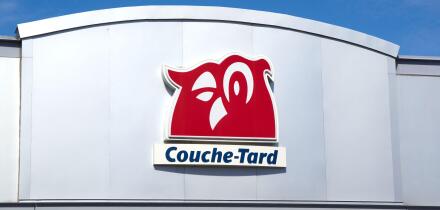 Montreal, Canada - April 4, 2020: Couche-Tard logo on a building over a blue sky. Couche-Tard, is a Canadian multinational operator of convenience sto
