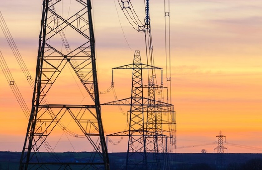 An electricity pylon of the National Grid in Wales at sunset