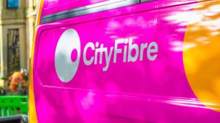 CityFibre logo on the side of van in the foreground while engineers commence work in the background