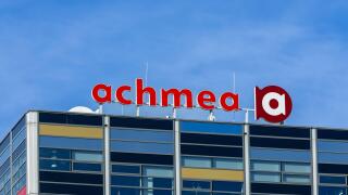 A modern office building featuring the prominent Achmea logo against a clear blue sky. Leiden, Netherlands, 3 May 2025.