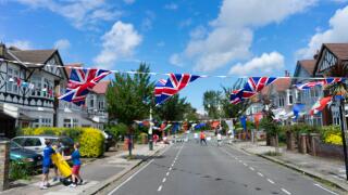 Bunting and union jack british flags at a street party event with kids playing. Image shot 2016. Exact date unknown.
