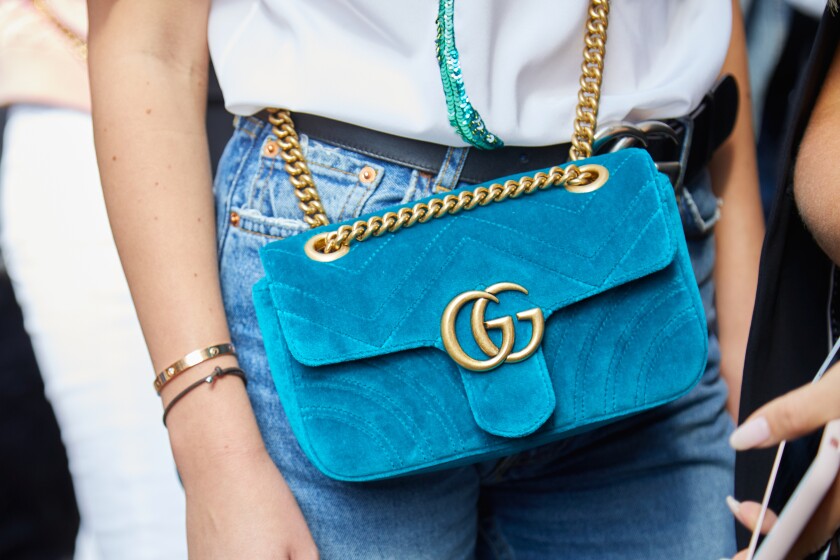 MILAN - SEPTEMBER 23: Woman with light blue velvet Gucci bag wit