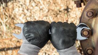 Hands with Work Gloves Holding a Wrench and Tighten very Rusty Bolts