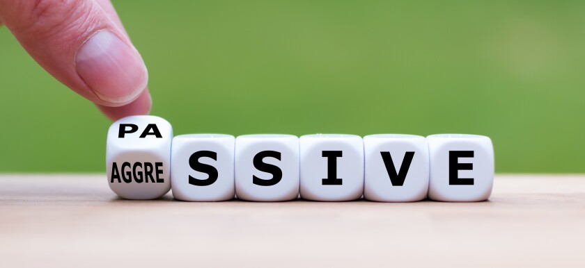 Hand turns a dice and changes the word "passive" to "aggressive", or vice versa.