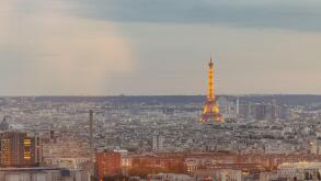 Panorama of Paris city, visible eiffel tower and close surroundings. Early evening setting in summer, tower lit by yellow lights.