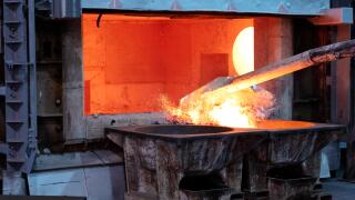 skimming melted aluminum for removing the dross before casting. Aluminum foundry works showing an open furnace
