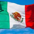 The Mexican flag on the background of a blue sky