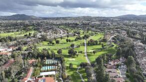 Aerial view of residential neighborhood surrounded by golf and valley during cloudy day in Rancho Bernardo, San Diego County, California. USA