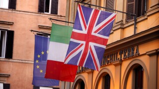 European, Italian and Union flags fly outside the Albergo Inghilterra in Rome, Italy.