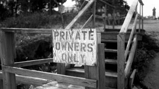 Private Owners Only hand painted sign at entrance to wooden steps and private property in East Hampton, NY.