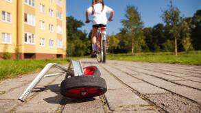 Girl on bicycle leaving her training wheels behind