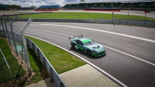 A racing car entering the pits on a track day at Silverstone Racing Circuit, Towcester, England.