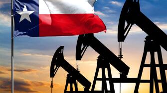 Oil rigs against the backdrop of the colorful sky and a flagpole with the flag State of Texas. The concept of oil production, minerals, development of
