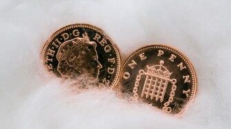 Two copper penny coins in close up wrapped in cotton wool for protection. Protecting money and austerity concept. UK