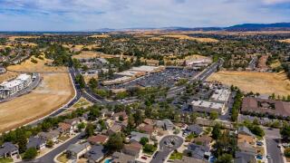 Drone images over a shopping center in Antioch, California. With cars in the parking lot and street lights